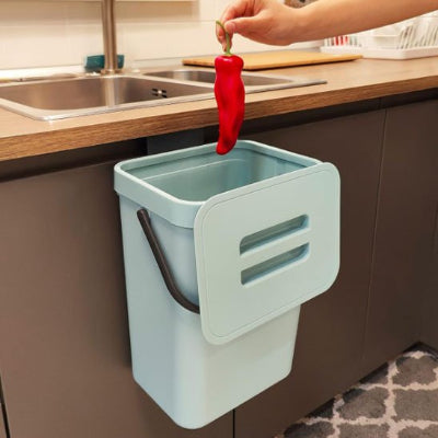 main jetant un piment dans poubelle sous evier cuisine bleu