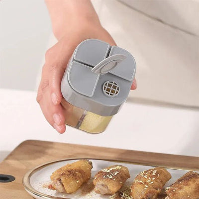 main utilisant le pot a epice pour saupoudrer le poulet
